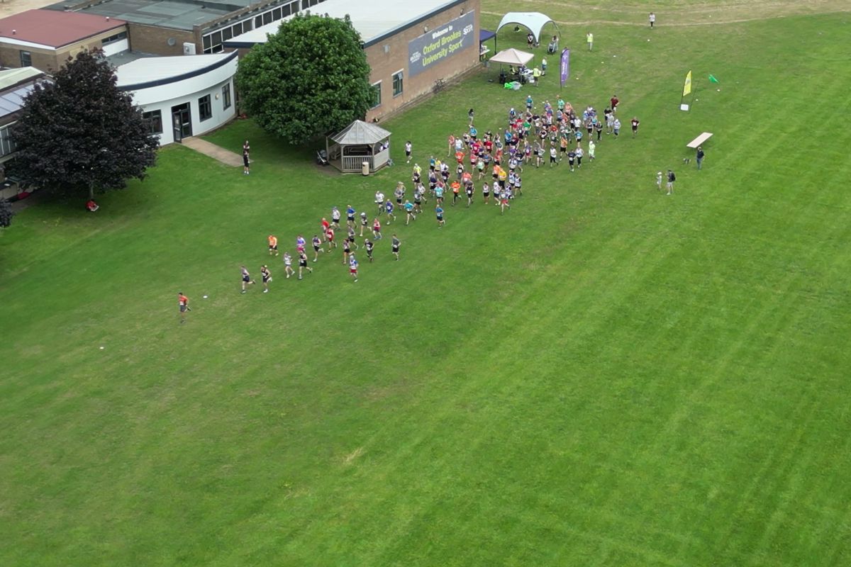 The field streaming away from the start beside the sports building, seen from above